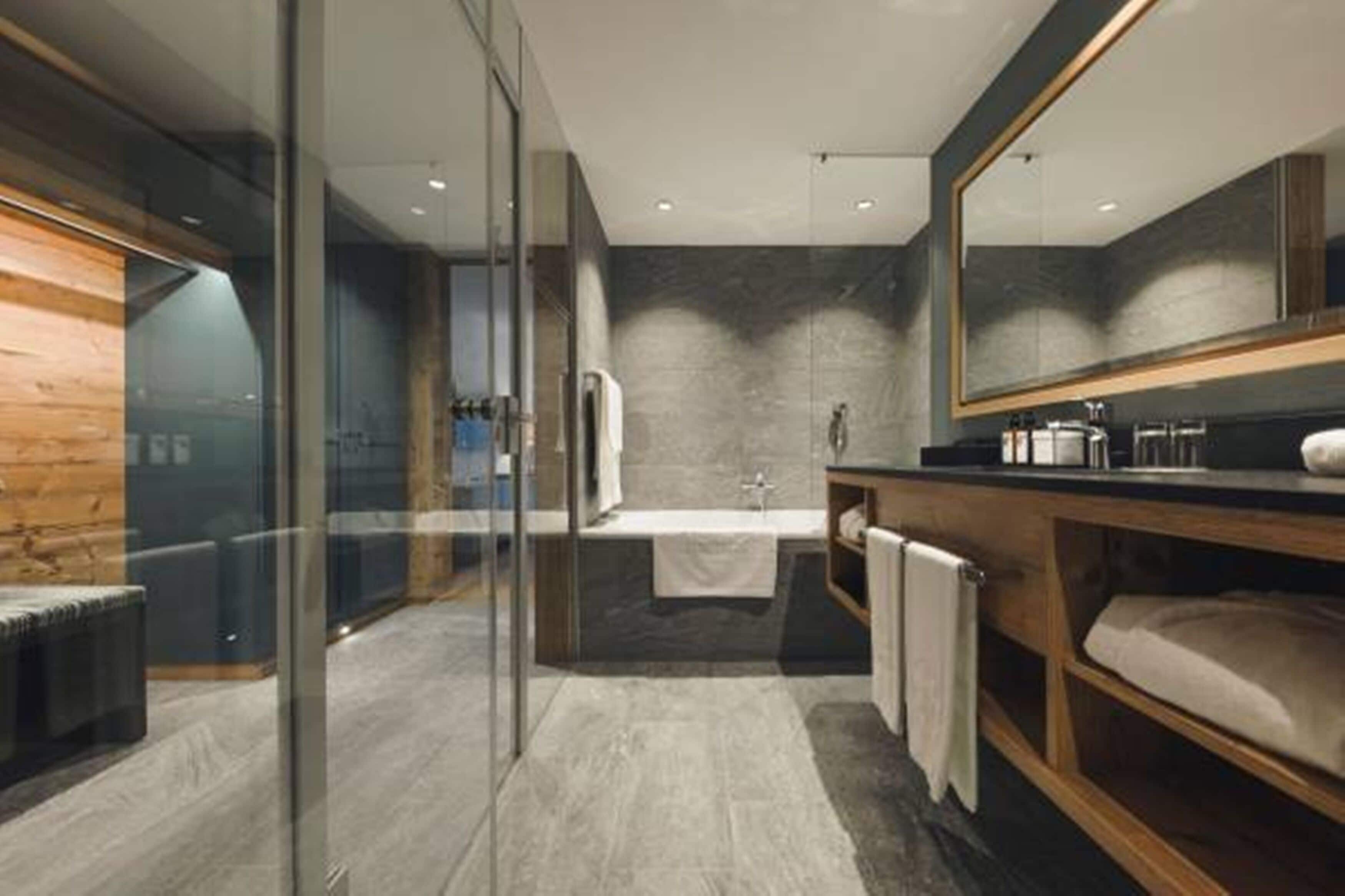 A modern bathroom with a glass shower enclosure, a freestanding bathtub, and a wooden vanity.