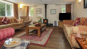 A cozy living room with a fireplace, sofas, a coffee table, and a TV.