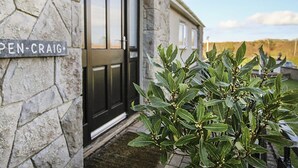 Un bâtiment en pierre avec une porte noire et une enseigne sur laquelle on peut lire « OPEN-CRAIG ».