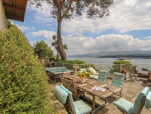 A patio with outdoor furniture, a ping pong table, and a view of a lake and mountains. - Tan Y Coed (Menai Bridge)