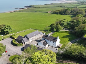 Escape to a serene rural retreat surrounded by green fields and a coastal backdrop.