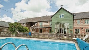 A swimming pool with metal ladders, surrounded by a wooden fence.