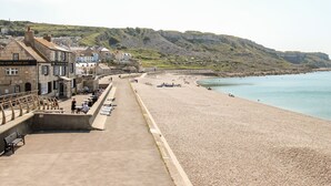Une ville côtière dotée d’une plage de galets, d’une promenade et de bâtiments, dont l’hôtel « The Cove House Inn ».