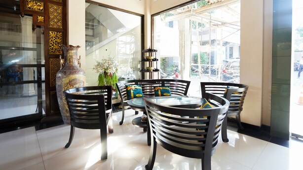 A modern interior with a glass partition, a decorative vase, and a dining area with chairs and a table.