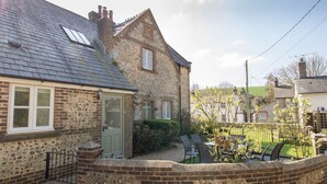 A stone house with a tiled roof, a green door, and a gravel driveway. - The Old School House (Dorchester)