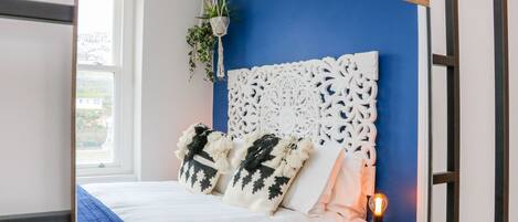 A bedroom with a bed, decorative headboard, and a bedside table with a lamp.