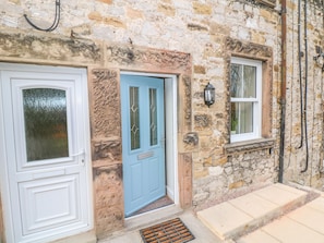 Traditional stone building with a classic entrance featuring two doors and a small stone window.
