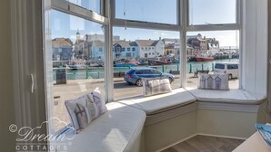A bay window with a view of a marina and buildings. - Harbour Edge (Weymouth)