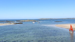 Un paisaje costero con una playa de arena y aguas tranquilas.