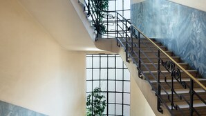 Eine prächtige Treppe mit aufwendigen schwarzen Geländern und einer Marmorwand.
