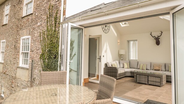 Un salon chaleureux avec une porte vitrée donnant sur un patio.