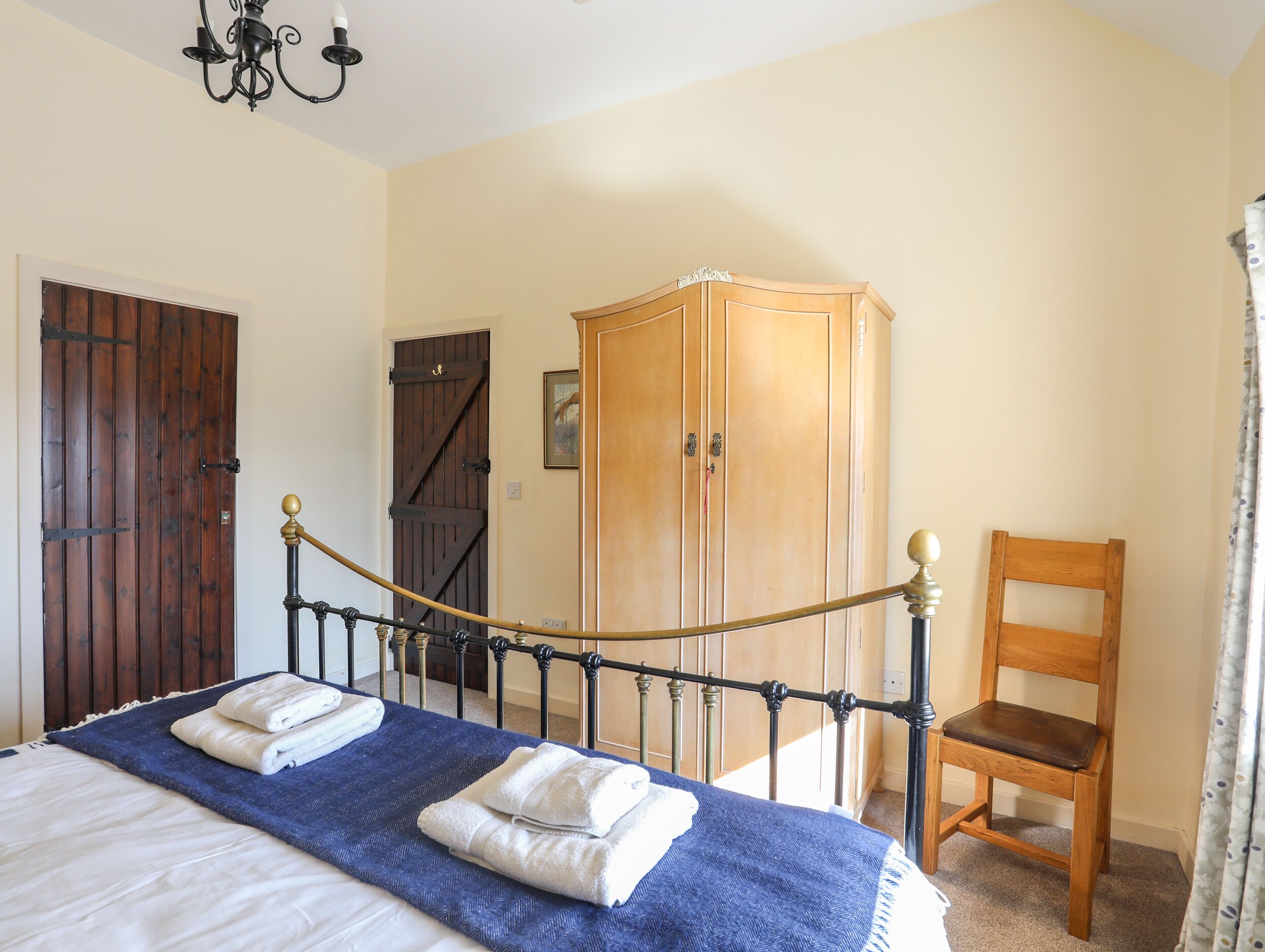 Un dormitorio con cama, armario, silla y puerta.
