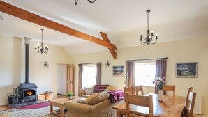 A cozy living room with a fireplace, wooden furniture, and a dining area.