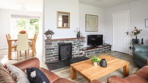 A living room with a fireplace, a television, a coffee table, and a sofa.