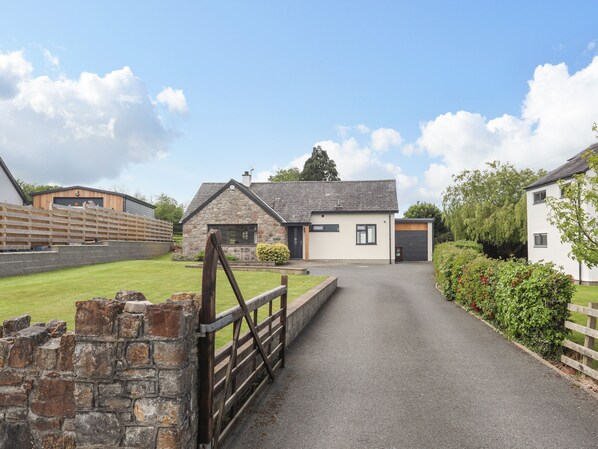 A rural property with a stone house, a paved driveway, and a wooden fence. - Bronallt (Y Felinheli)