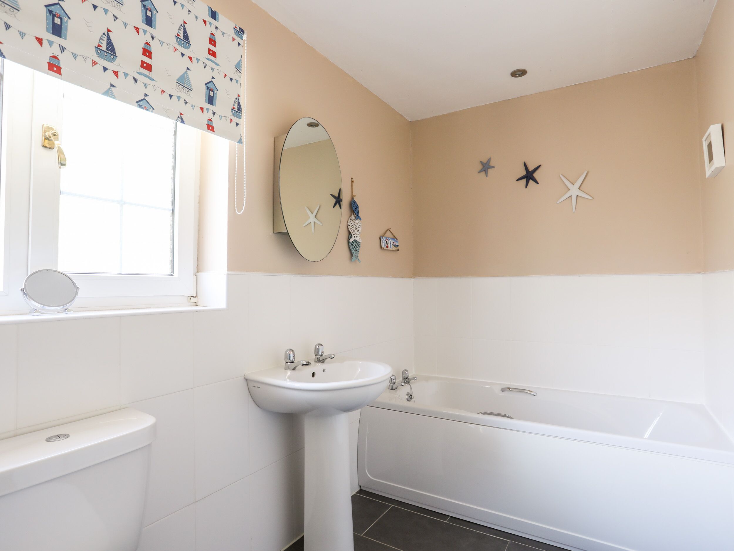 A bathroom with a toilet, sink, and bathtub.