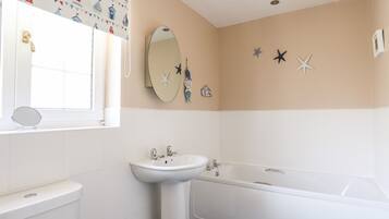 A bathroom with a toilet, sink, and bathtub.