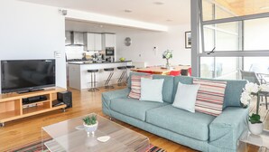 Ein modernes Wohnzimmer mit einer Couch, einem Couchtisch und einem Fernseher.