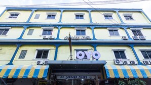 A multi-story building with a yellow facade and blue trim. The ground floor has a sign for CV. Laksana Piling, a special construction company. - OYO 2097 Hotel Laksana Inn (Batam)