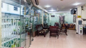 A hotel lobby with glass partitions, wooden furniture, and a sign indicating a salon. - OYO 2097 Hotel Laksana Inn (Batam)