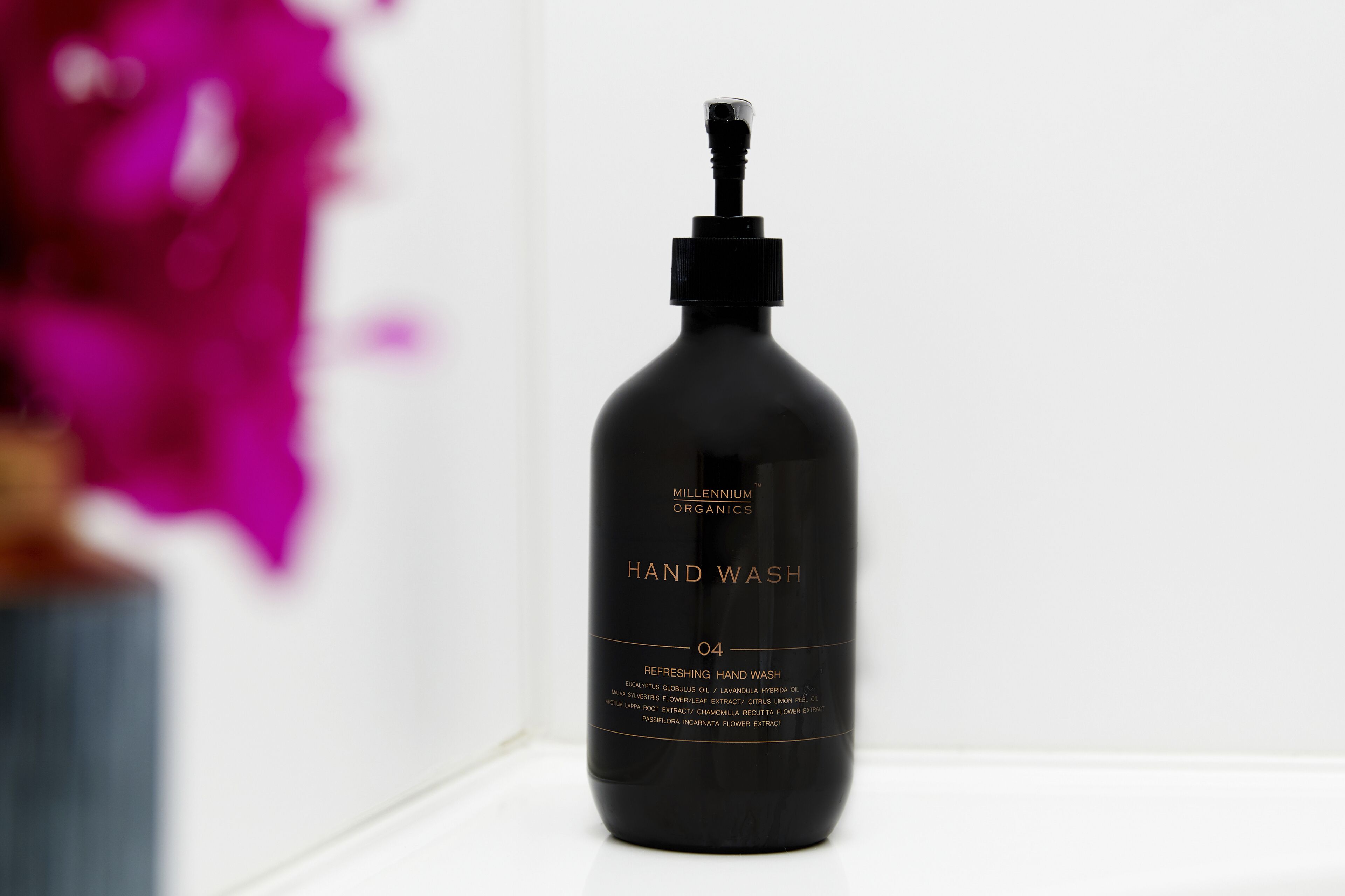 A black bottle of Millennium Organics Hand Wash on a white surface.