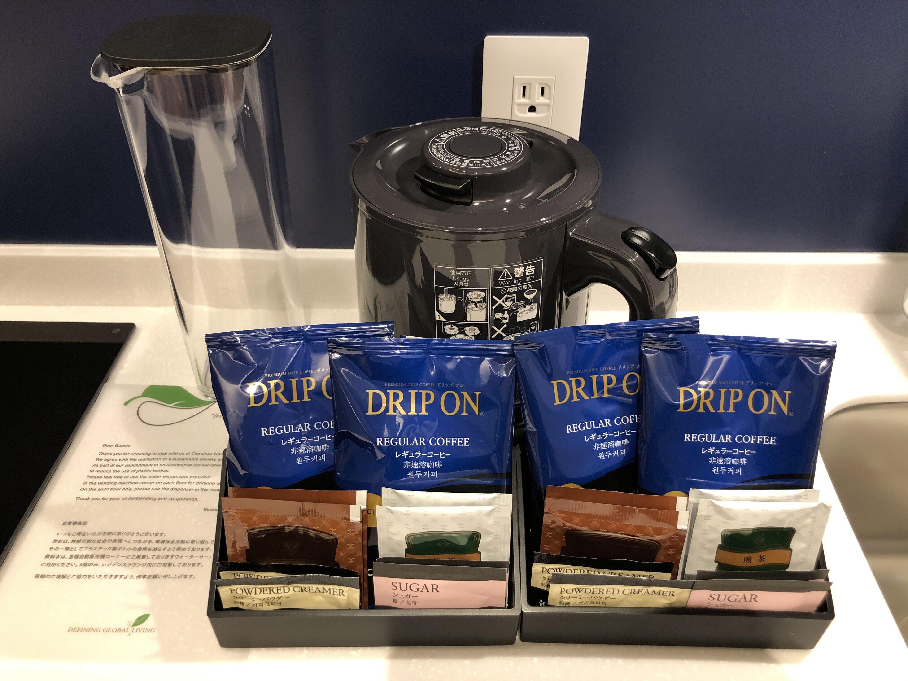 A coffee station with drip coffee packets, powdered creamer, and sugar packets.