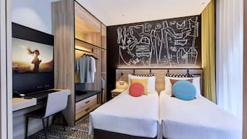 A hotel room with a bed, a desk, a TV, and a wall art piece.