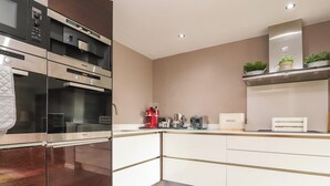A modern kitchen with built-in appliances, a coffee machine, and a bread box. - Underfell (Carnforth)