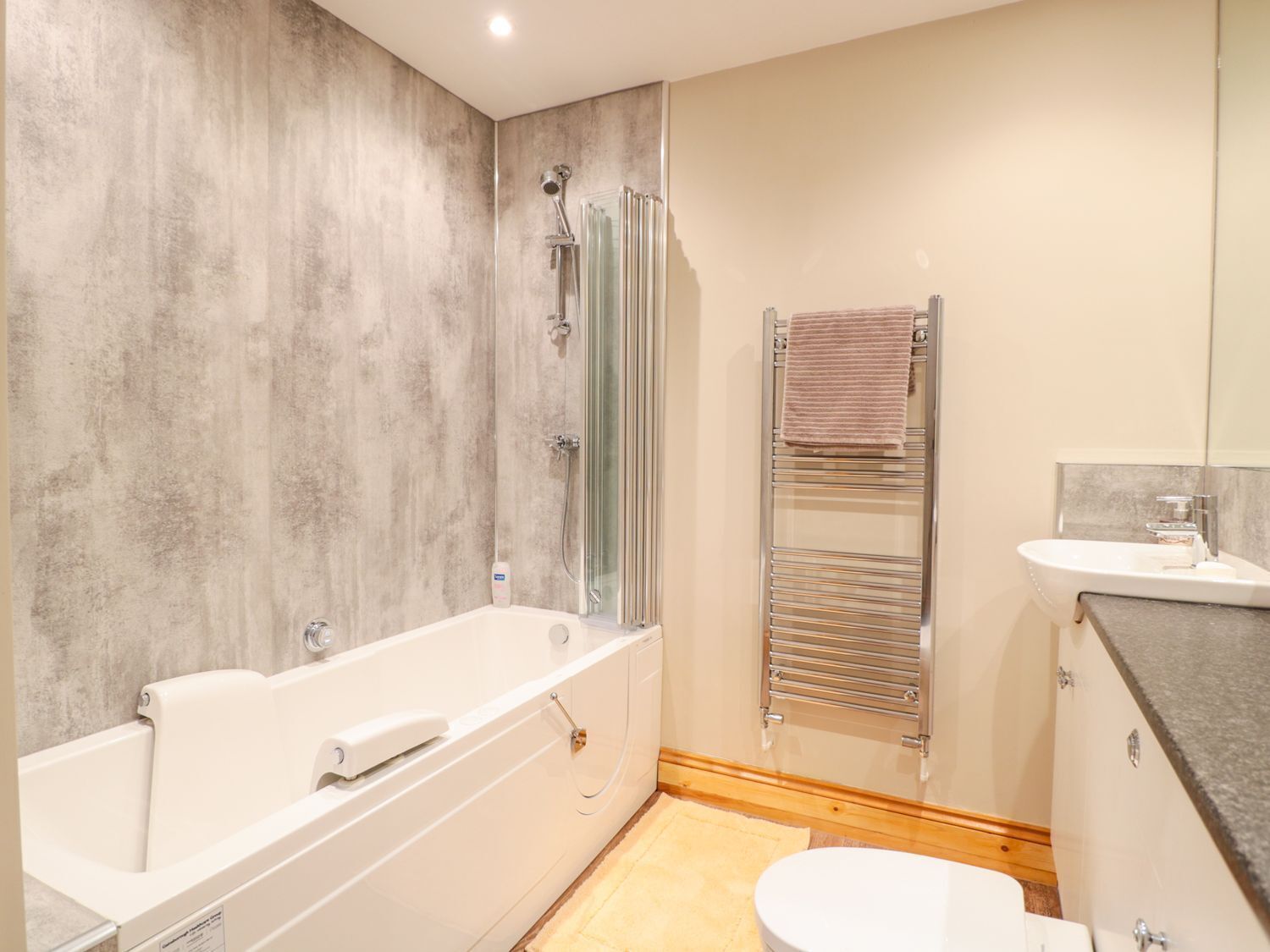 A modern bathroom with a bathtub, a shower, a toilet, and a sink.