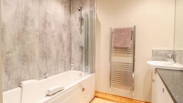 A modern bathroom with a bathtub, a shower, a toilet, and a sink.