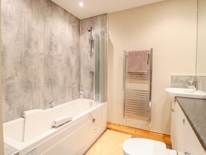 Un baño moderno con bañera, ducha, inodoro y lavabo.
