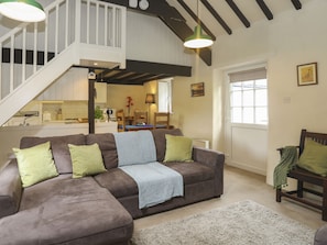 Relax in a spacious living area with a comfortable sofa, shag rug, and high ceiling.