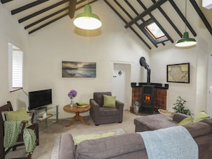 Relax in this inviting living room with a comfortable sofa, armchair, and fireplace.