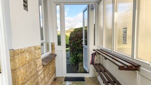 A narrow hallway with a stone wall on one side and a bench on the other. - Shipton Hill View (Bridport)