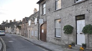 A row of stone buildings with a sign indicating a Model Village and Tea Room. - Tavern Way (Wareham)