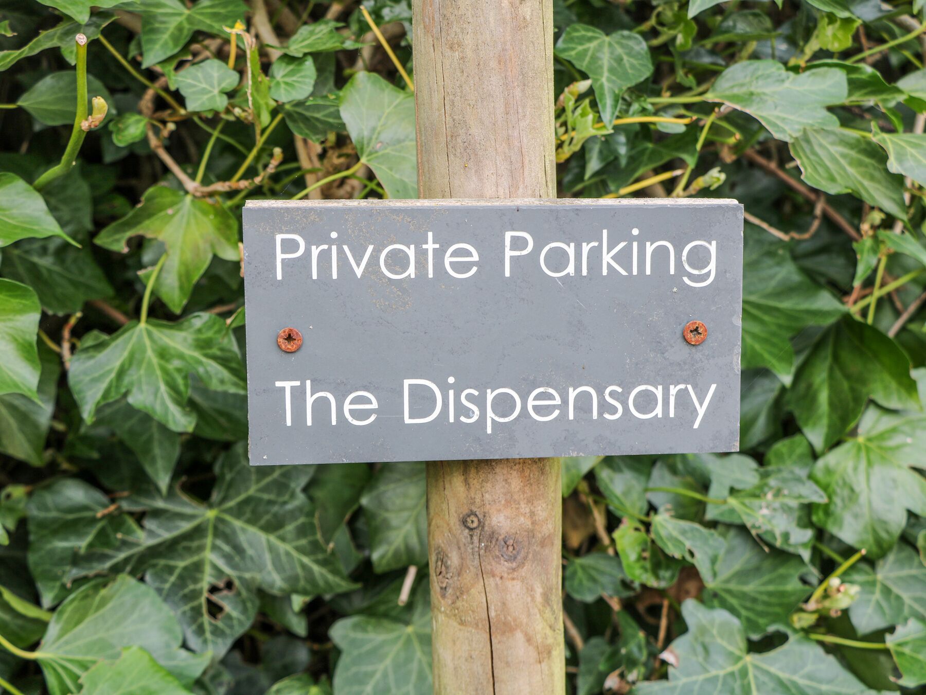 Un panneau indiquant un parking privé à l’établissement The Dispensary.