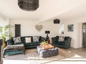 Relax in this stylish living room with a large sectional sofa and tufted ottoman.