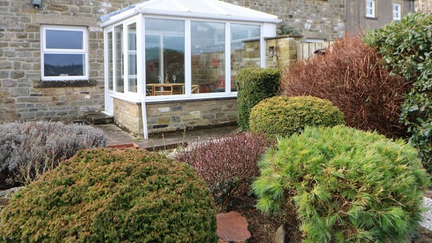 A stone building with a conservatory.