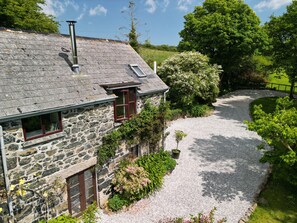 Escape to a serene cottage surrounded by lush greenery and mature trees.
