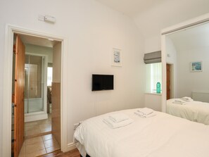 A hotel room with a bed, a TV, a bathroom, and a shower. - Tyn Towyn - Bwthyn Haf (Holyhead)