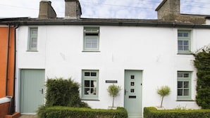 Un bâtiment blanc avec des volets verts et une enseigne sur laquelle on peut lire « Gorffwysfa ».