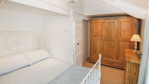 Une chambre à coucher avec un lit, une armoire en bois et un lustre.