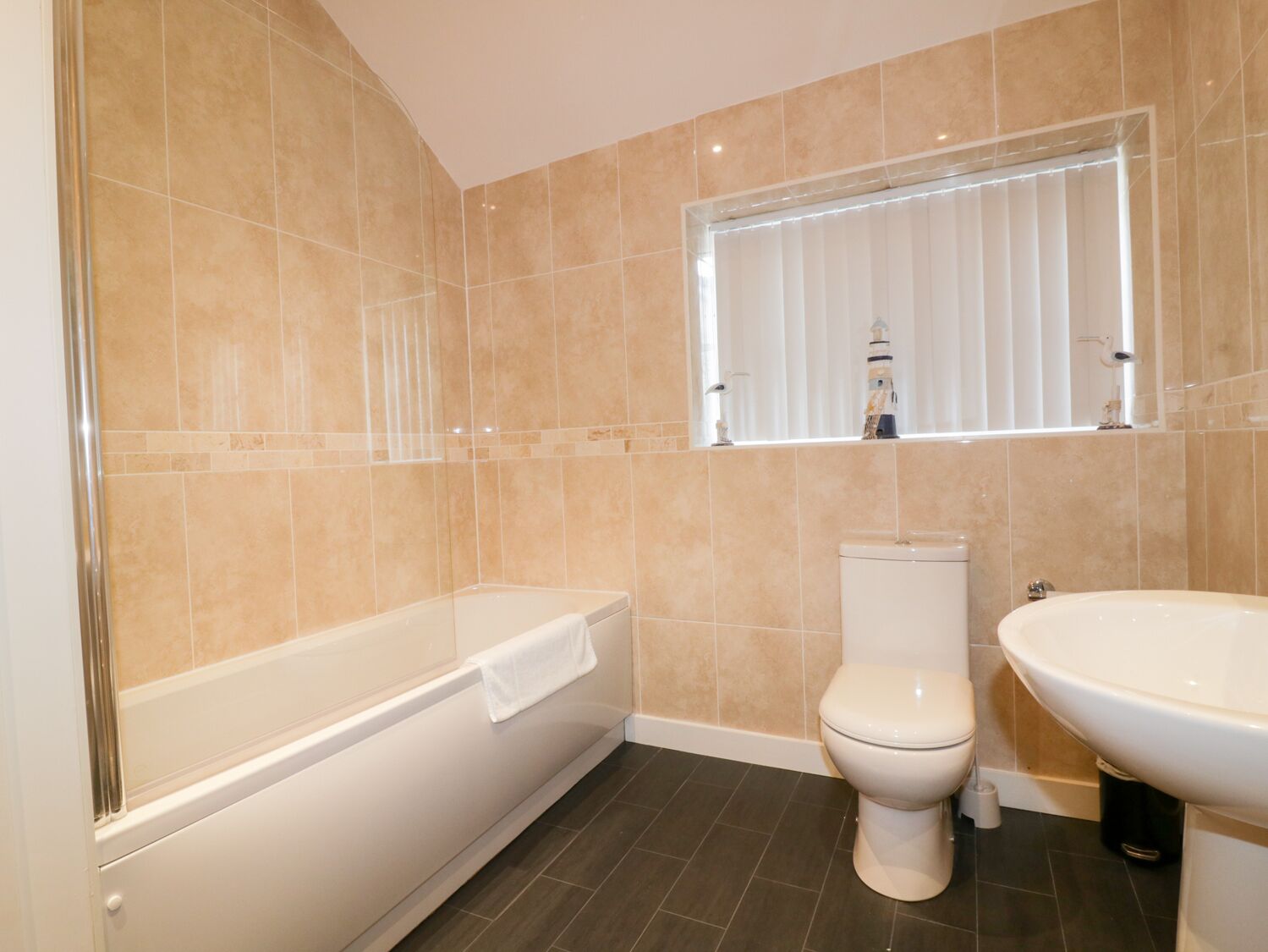 A modern bathroom with a bathtub, toilet, and sink.