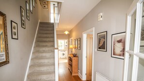 A staircase leading to a laundry area with a wooden floor and a radiator on the wall.
