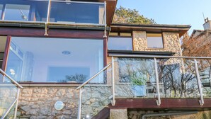 A modern two-story house with large windows and a stone facade. - Shady Bowers (Carnforth)
