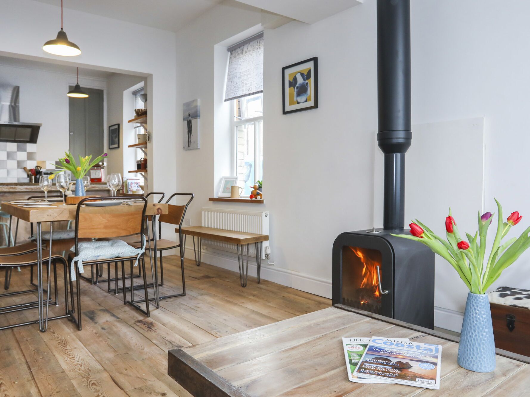 A cozy living room with a fireplace, wooden furniture, and a dining area.