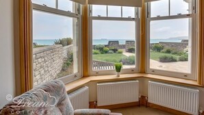 Une chambre d’angle dotée de grandes fenêtres donnant sur un jardin et la mer.