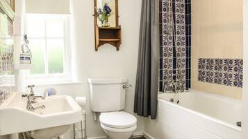 A bathroom with a toilet, sink, and bathtub.