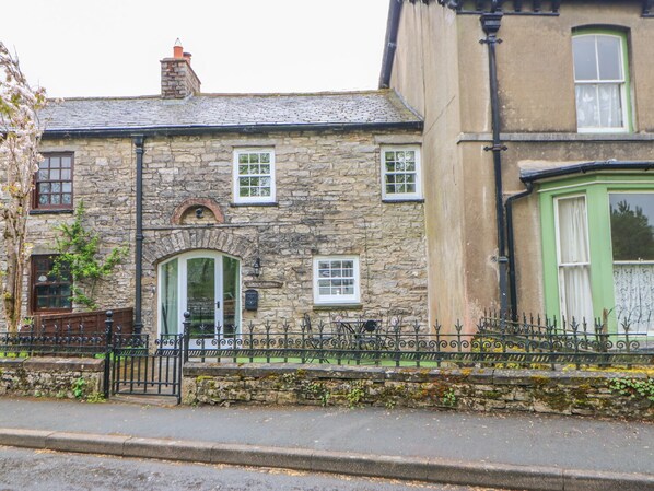 A stone cottage with a green door, a small porch, and a sign reading "Linden Cottage." - Linden Cottage (Kirkby Stephen)