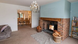A cozy living room with a fireplace, a dining area, and a bookshelf. - Shatterford Lakes (Bewdley)
